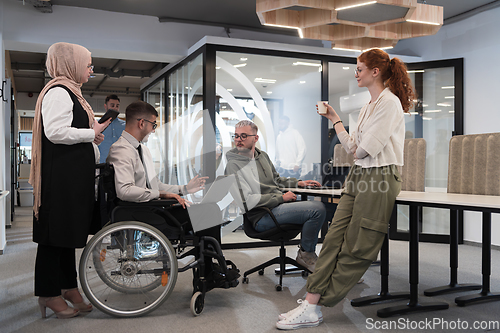 Image of Young group of business people brainstorming together in a startup space, discussing business projects, investments, and solving challenges.