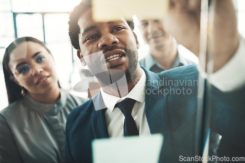 Image of Businessman, writing and planning schedule, brainstorming or strategy on glass wall at office. Group of employee workers in team project plan, tasks and write for post it or sticky note together