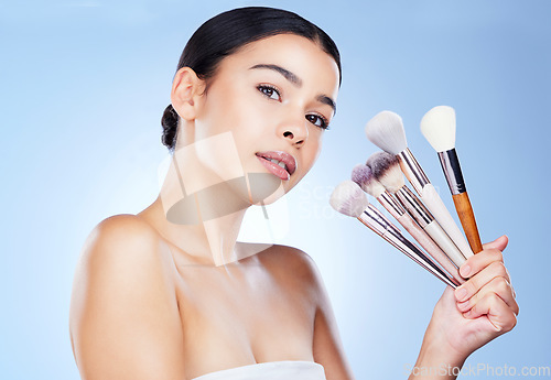 Image of Makeup, beauty brushes and portrait of woman on blue background for cosmetics, powder and foundation. Cosmetology, salon aesthetic and face of girl with tools for application, wellness and skin glow