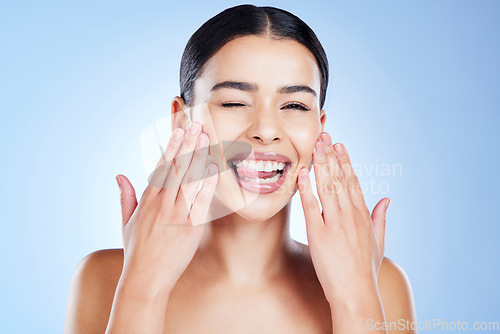 Image of Skincare, beauty and portrait of woman with tongue out in studio of makeup, cosmetics or blue background. Young female model, funny face and wink expression for facial aesthetic, glow and happy emoji