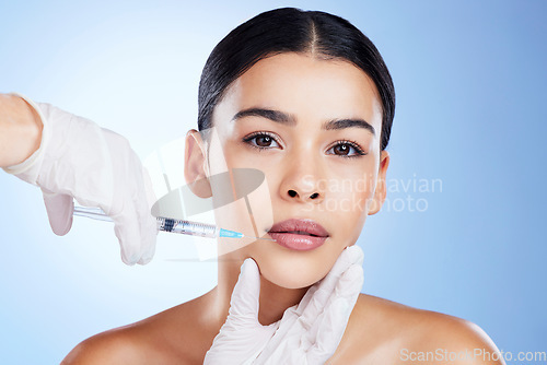 Image of Plastic surgery, woman and surgeon hands for beauty, filler syringe and change in studio. Aesthetic model person and doctor for cosmetic injection, face transformation or dermatology blue background