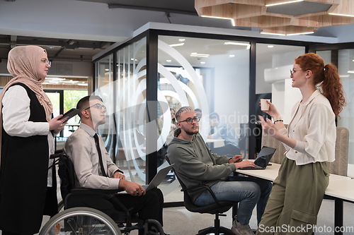 Image of Young group of business people brainstorming together in a startup space, discussing business projects, investments, and solving challenges.