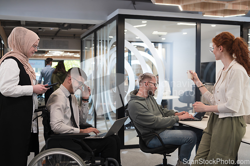 Image of Young group of business people brainstorming together in a startup space, discussing business projects, investments, and solving challenges.