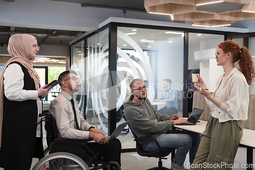 Image of Young group of business people brainstorming together in a startup space, discussing business projects, investments, and solving challenges.