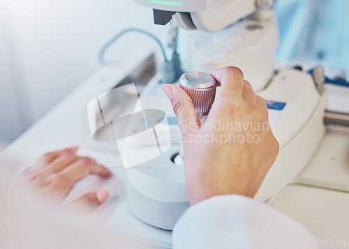 Image of Ophthalmology, test and hand of a doctor on a machine for a consultation, vision check and monitor lens. Medicine, healthcare and optician moving a handle on equipment for analysis of eyes and retina