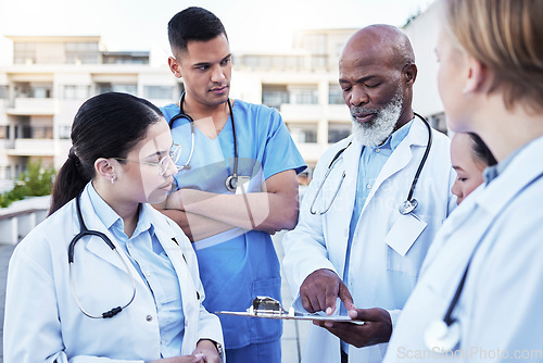 Image of Doctor, team and planning with clipboard in the city for healthcare schedule, appointments or collaboration. Group of doctors, medical student or internship in teamwork discussion, medicine or tasks