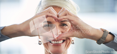 Image of Portrait, hands and heart with a business woman in the office, feeling love for her corporate career. Face, emoji or hand sign with a senior female manager or ceo work looking happy and confident