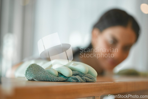 Image of Cleaning, hands and a woman at a table to clean surface from dirt, dust or bacteria for healthy home. Fabric or cloth of maid or cleaner wipe wood furniture with polish or chemical to disinfect