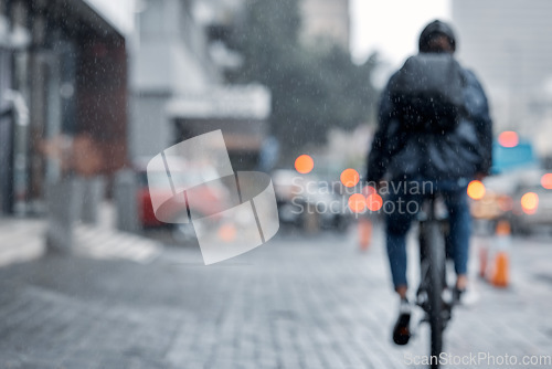 Image of Cyclist, bicycle and delivery in the city on rainy day or cold weather in an urban town on mockup. Biker riding in the rain with cargo, transport or deliver service in a urban town street for courier