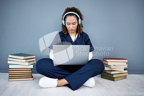 Image of Doctor, laptop or headphones of hospital music, podcast or radio in woman study research or mock up learning by wall. Thinking, technology or medical student listening to healthcare audio for books