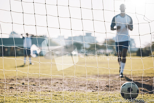Image of Sports, soccer and ball in net after goal, score and winning on field for training, practice and game match. Motivation, football club mockup and players outdoors for fitness, exercise and workout