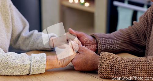 Image of Couple, holding hands and closeup for praying in home with faith, religion and hope for peace at desk. People, prayer and together with support, empathy and care with worship for connection to God