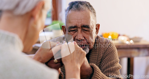 Image of Senior couple, holding hands and praying in home for religion, hope or love for mindfulness. Elderly man, woman and support for peace, prayer and gratitude for connection to God, holy spirit or faith