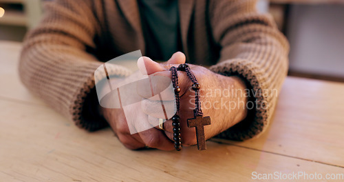 Image of Hands, rosary and cross with closeup for religion, peace and hope at desk, home or praying for worship. Person, crucifix and jewelry for faith, mindfulness and connection to holy spirit, Jesus or God