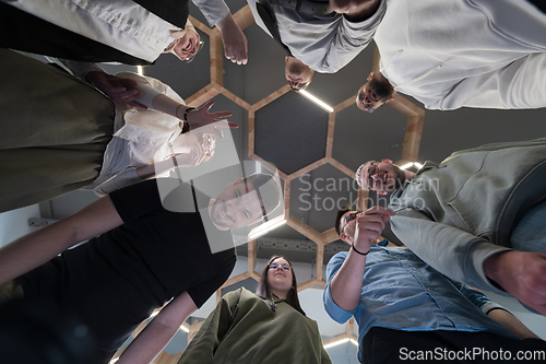 Image of In a modern office, a group of young business professionals is captured in a warm and embracing hug, reflecting the spirit of unity, collaboration, and shared success in their dynamic workplace.