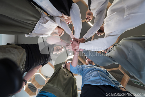 Image of A group of young businessmen offer their hands together, symbolizing togetherness in the business world