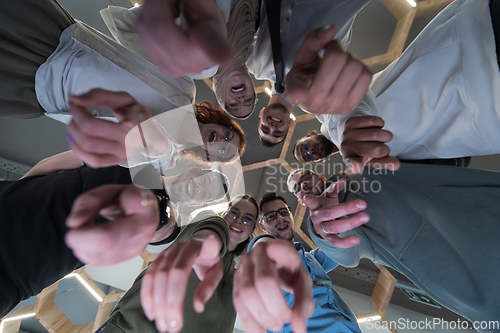 Image of In a modern office, a group of young business professionals is captured in a warm and embracing hug, reflecting the spirit of unity, collaboration, and shared success in their dynamic workplace.