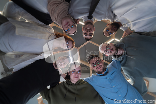 Image of In a modern office, a group of young business professionals is captured in a warm and embracing hug, reflecting the spirit of unity, collaboration, and shared success in their dynamic workplace.