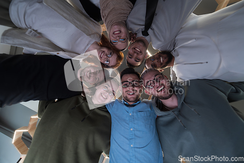 Image of In a modern office, a group of young business professionals is captured in a warm and embracing hug, reflecting the spirit of unity, collaboration, and shared success in their dynamic workplace.