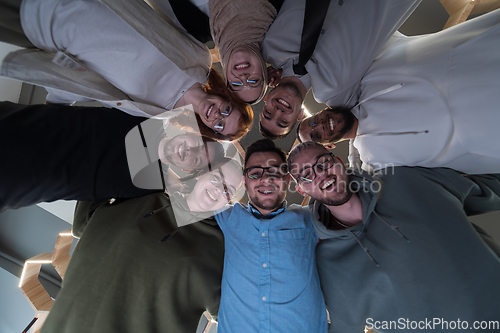 Image of In a modern office, a group of young business professionals is captured in a warm and embracing hug, reflecting the spirit of unity, collaboration, and shared success in their dynamic workplace.