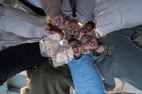 Image of In a modern office, a group of young business professionals is captured in a warm and embracing hug, reflecting the spirit of unity, collaboration, and shared success in their dynamic workplace.