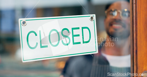Image of Happy man, small business or closed sign on window in coffee shop or restaurant for end of service. Closing time, smile or manager with board, poster or message in retail store or cafe for notice