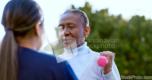 Image of Dumbbell, fitness and a senior black woman with a nurse outdoor in a garden together for physiotherapy. Exercise, health or wellness with an elderly patient and medical person in the yard to workout