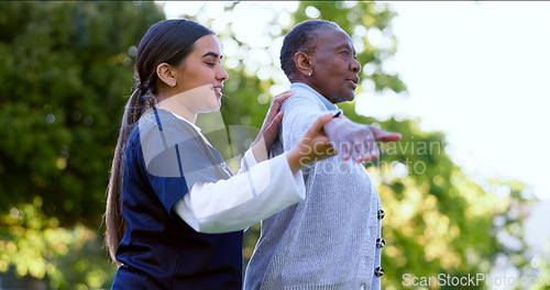 Image of Senior, woman and nurse with arm stretching for exercise, workout or fitness in a park with smile. People, professional or caregiver with activity for physiotherapy, wellness and health in nature