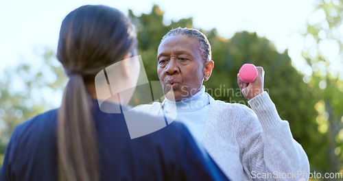 Image of Dumbbell, fitness and a senior black woman with a volunteer outdoor in a garden together for physiotherapy. Exercise, health or wellness with an elderly patient and nurse in the yard to workout