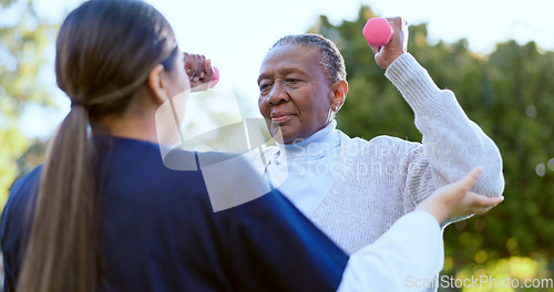 Image of Dumbbell, fitness and a senior black woman with a nurse outdoor in a garden together for physiotherapy. Exercise, health or wellness with an elderly patient and volunteer in the yard to workout