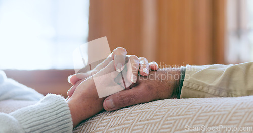 Image of Comfort, support and senior couple holding hands in living room at modern home for romance and compassion. Love, empathy and closeup of elderly man and woman with affection in the lounge of a house.