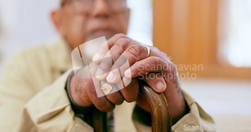 Image of Hands, walking stick and a senior person with a disability in the living room of a home closeup for retirement. Balance, retirement and wellness with an elderly adult holding a cane for support