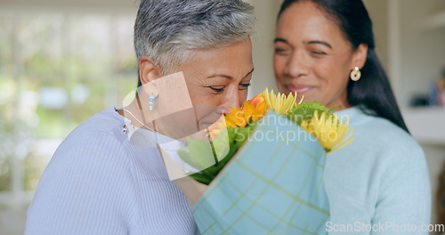 Image of Love, flowers and mother and daughter in home for bonding, relationship and celebrate together. Family, happy and mature mom embrace adult woman for mothers day, support and birthday in living room