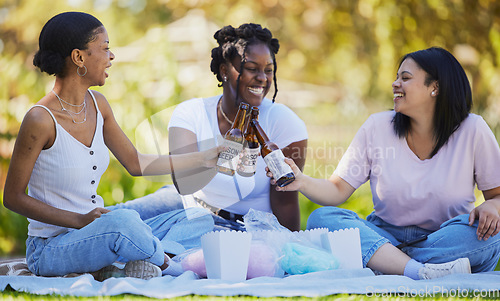 Image of Black women, picnic and beer toast in park, nature environment or sustainability garden with food, popcorn or cotton candy. Smile, happy friends or bonding students with alcohol in celebration social