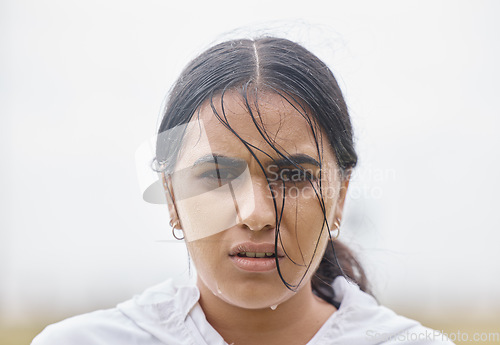 Image of Rain, fitness and face portrait of woman in training resting on a cardio workout break outdoors in nature. Runner, winter and healthy Indian girl sweating in raining weather after sports exercise