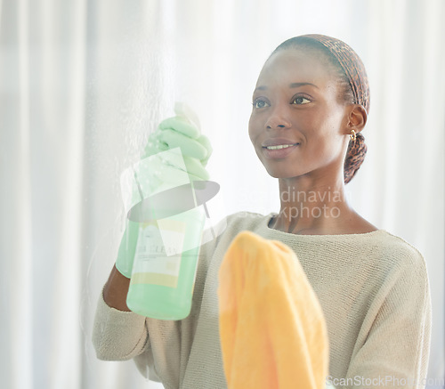 Image of Cleaning, black woman and spray product of a cleaner washing a mirror with a smile. Working maid doing home hygiene with a bottle and cloth to disinfect the house furniture, glass and window