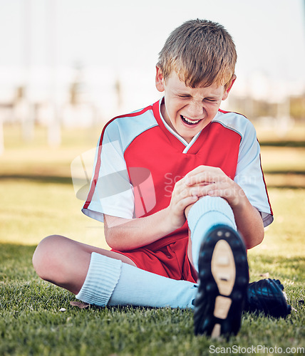 Image of Soccer, knee injury and pain on a field after match, training or fitness exercise at stadium pitch. Sports, football and boy in a medical emergency with torn muscle, sprain or broken bone in his leg.