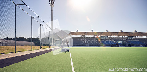 Image of Field, sports and hockey ground at empty stadium for fitness, training or professional game day. Competition, exercise or sport playground for athletic cardio turf with Canada sun flare.