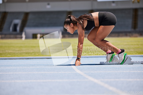 Image of Running, sports and fitness with an asian woman athlete on a track for a race, marathon or endurance training. Health, workout and exercise with a female runner at the start of a competitive sport