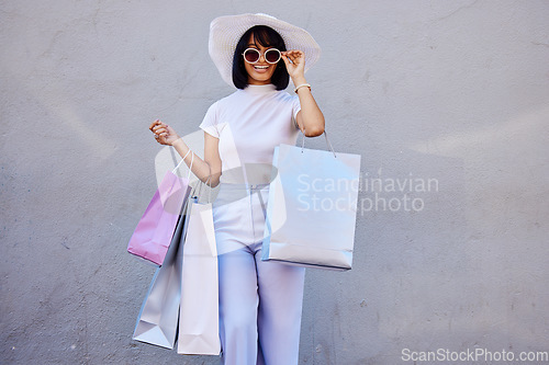 Image of Retail, shopping and fashion with portrait of woman and sunglasses for mockup on gray wall, mall or sales. Product, happy and designer store with girl customer for luxury, smile or discount with bags