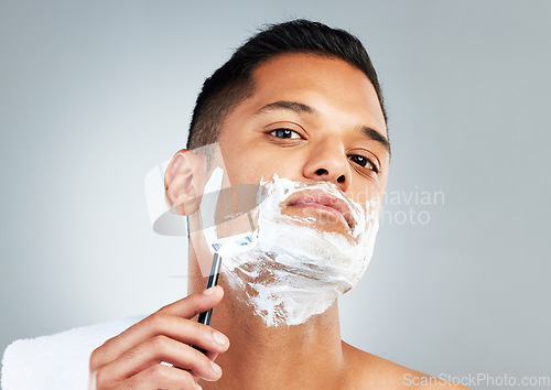 Image of Man, razor and skincare in beauty for grooming, shave or clean hygiene against a grey studio background. Male face shaving beard with cream, cosmetics and care for healthy or fresh skin