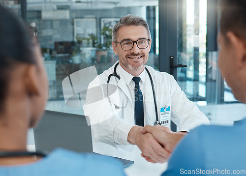 Image of Handshake, nurse and doctor shaking hands after success in a medical surgery at a trustworthy hospital. Partnership, collaboration and physician welcomes a healthcare worker to the team in a meeting