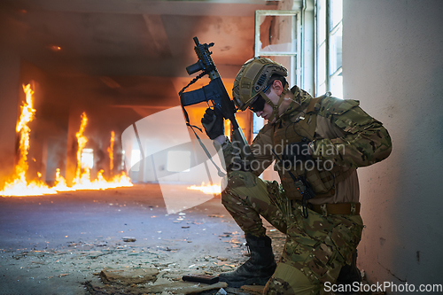 Image of Soldier in action near window changing magazine and take cover