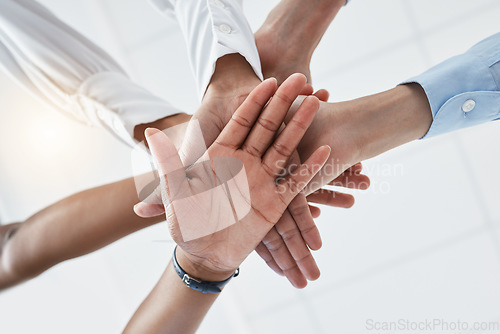 Image of Hands, collaboration and motivation with a team in business standing in a huddle or circle from below. Teamwork, success and unity with an employee group working together with a goal or vision