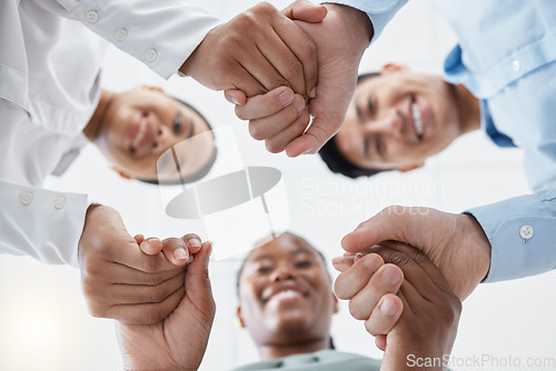 Image of Diversity, support and collaboration of business people holding hands below in trust for company success. Team of corporate workers in a circle of success in a meeting together at a corporate company