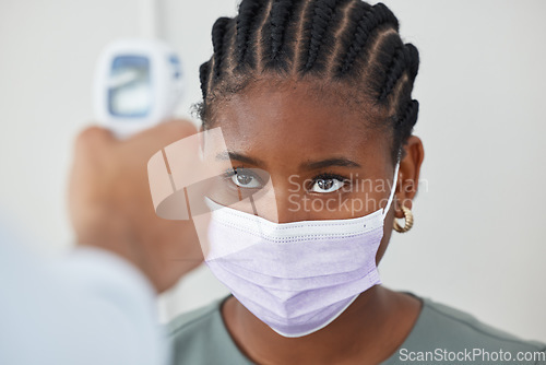 Image of Face mask, thermometer and covid with doctor, medical expert and healthcare worker in clinic, hospital or wellness center. Black woman or patient with medical checking fever to prevent disease