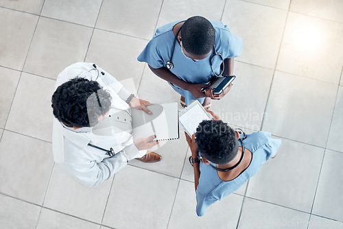 Image of Doctors, documents and tablet for medical teamwork, insurance and wellness research in hospital. Above healthcare professional group, surgery planning and consulting digital tech data with paperwork