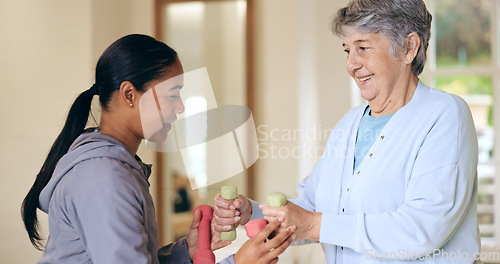 Image of Dumbbell weights, rehabilitation and an old woman with a caregiver in a nursing home for training. Health, fitness or exercise with a senior patient and volunteer in a living room for physiotherapy