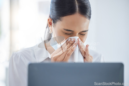 Image of Covid, sick and blowing nose with a business woman sneezing into a tissue while suffering with a cold, flu or allergies in the office. Hands, nasal and hayfever with a young female employee at work