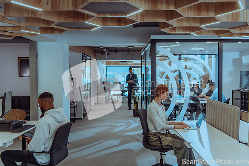 Image of Young group of business people brainstorming together in a startup space, discussing business projects, investments, and solving challenges.